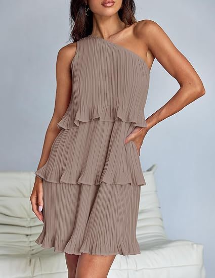 Woman wearing a one-shoulder, tiered dress against a neutral background